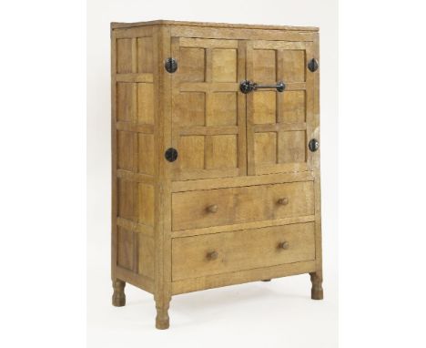 A Robert 'Mouseman' Thompson oak cabinet or tallboy,the adzed top over a  panelled cupboard with blackened iron work opening 