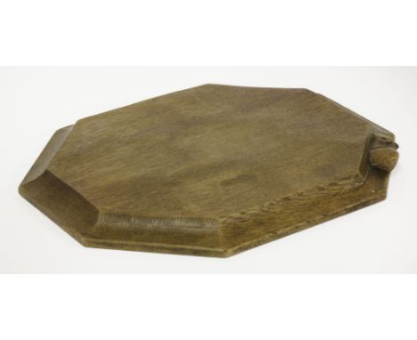 An oak octagonal cheeseboard,by Robert 'Mouseman' Thompson, with a chamfered edge, carved with a signature mouse,30.5cm wide2