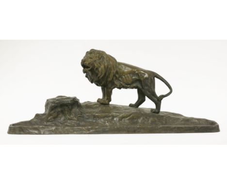 A bronze desk stand,modelled with a lion on a rocky outcrop, signed 'Kucharyk(?)', with an inkwell to one side, a hinged cove