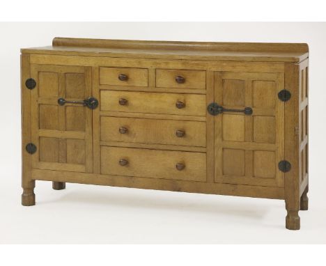 A Robert 'Mouseman' Thompson oak sideboard,the adzed top over five drawers with turned handles flanked with panelled cupboard