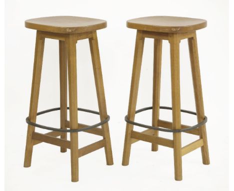 A pair of Robert 'Mouseman' Thompson bar stools,the dished seats, raised on chamfered supports, united with rails and an iron