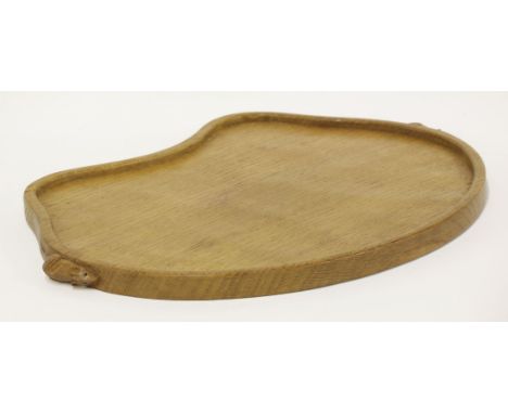 A Robert 'Mouseman' Thompson bread board,with an adzed top, with a raised border, carved both sides with the mouse signature,