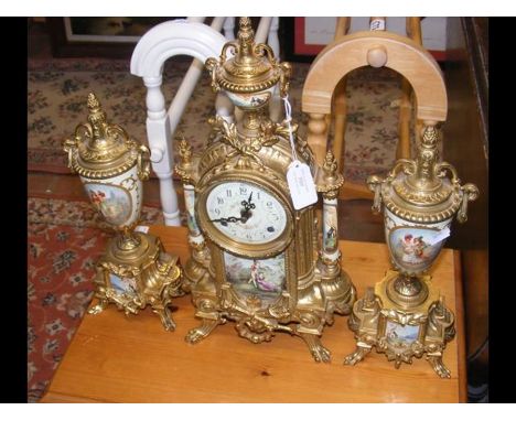 A gilt German mantel clock with matching garnitures