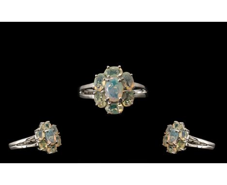 Opal Seven Stone Cluster Ring, an oval cut opal with an excellent display of colours, set with a further six smaller, similar