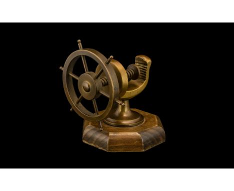 Novelty Nut Cracker in the form of a ship's wheel, made of brass on an oak base.  Very tactile, good patina in relation to ag