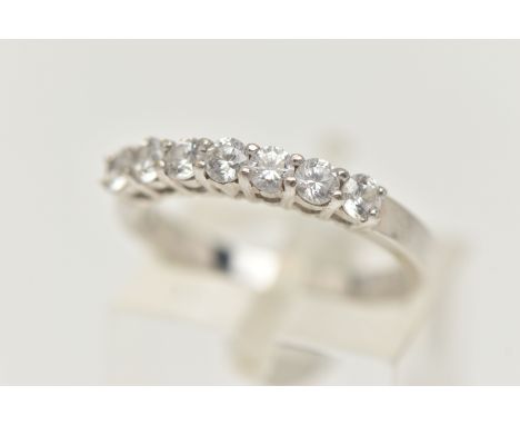 A 9CT WHITE GOLD CUBIC ZIRCONIA RING, designed as a line of seven circular cubic zirconia stones, to the plain band, 9ct hall