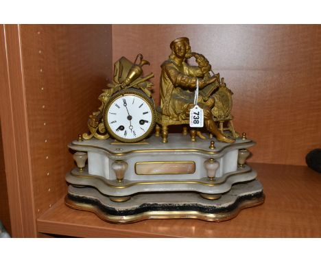 A LATE 19TH CENTURY GILT METAL AND ALABASTER MANTEL CLOCK, modelled as an artist seated beside the drum shaped clock, enamel 