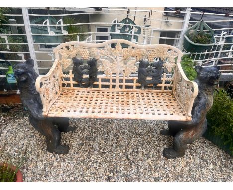 A CAST IRON BLACK FOREST STYLE GARDEN BENCH, the seat is supported by two angry black bears, the lattice seat surrounded by f