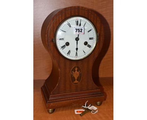 AN EDWARDIAN MAHOGANY BALLOON SHAPED MANTEL CLOCK, oval inlay with trophy, enamel dial with Roman numerals, eight day movemen