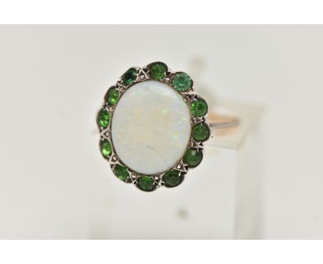 AN OPAL RING, the central opal cabochon within a green gem surround, assessed as green paste, unmarked, ring size J 1/2, appr