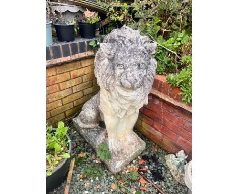 A PAIR OF WEATHERED COMPOSITE SEATED GARDEN LIONS, on a square plinth base, width 35cm x depth 67cm x height 96cm (condition 