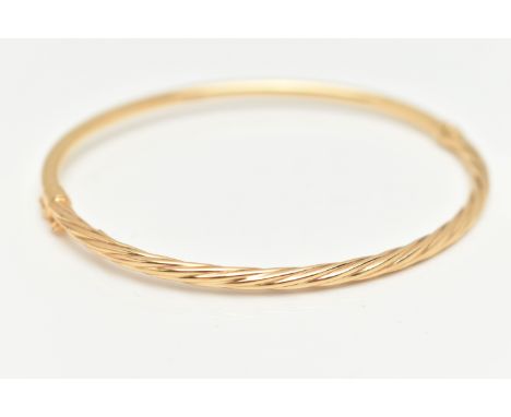 A YELLOW METAL TWIST HINGED BANGLE, part twisted part polished hinged bangle, stamped 375, fitted with a figure of eight safe