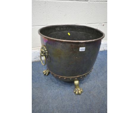 A 19TH CENTURY RIVETED BRASS AND COPPER COAL BUCKET, with lions head handles, and triple paw feet, diameter 46cm x height 43c