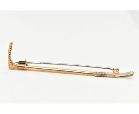 AN EARLY 20TH CENTURY YELLOW METAL RIDING CROP BROOCH, stamped 9ct, makers mark A&amp;W, length 78mm, fitted with a white met