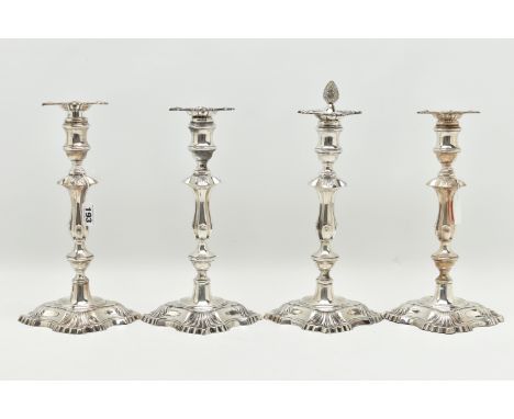 A GEORGE V SILVER SET OF FOUR CANDLESTICKS  IN GEORGE II STYLE, with removable shaped square drip pans, waisted knopped stems