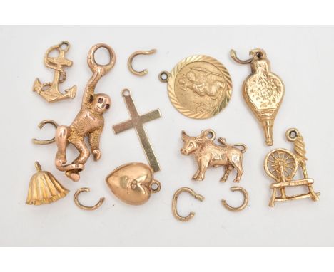 A SMALL BAG OF 9CT GOLD CHARMS, to include a bull, bell, bellowers, anchor, St. Christopher, cross, puffy heart and spinning 