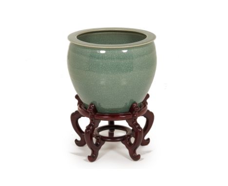 A CELADON PLANTER ON HARDWOOD STAND
With a green celadon crackled glaze
36cm high x 42cm diameter (without stand)
Condition: 