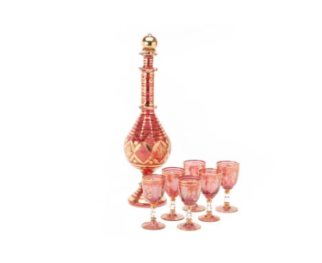 A LARGE RUBY GLASS DECANTER AND SIX GLASSES
With gilt decoration
Decanter 46cm high
Condition: Minor signs of wear commensura