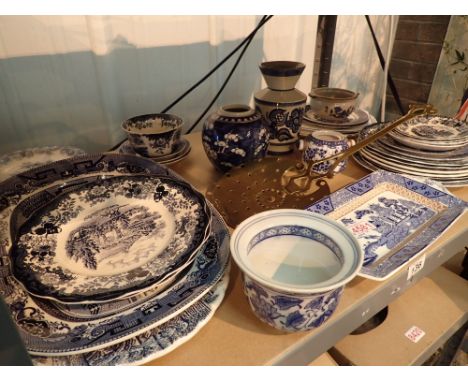 Shelf of blue and white ware with a brass skimmer 