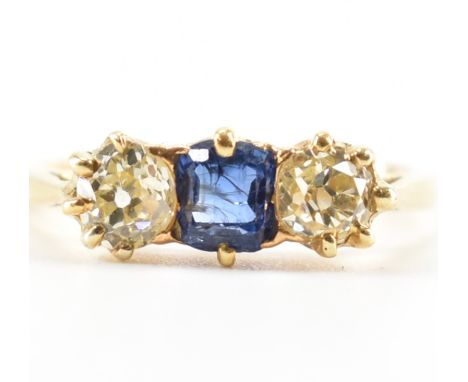 An 18ct gold sapphire and diamond three stone ring. The ring set with a central step cut sapphire flanked by two old cut diam