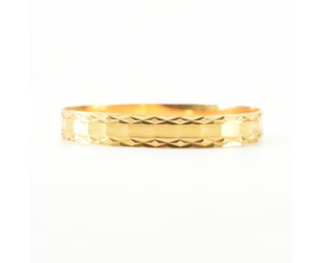A high carat gold bangle. The bangle having diamond cut decoration to plain band. Assay mark to the interior of the bangle. W