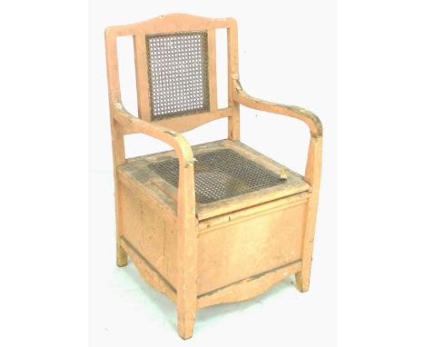 A Victorian commode chair, painted pink, with lift caned seat, and open arms, 57.5 61 by 101cm high. 