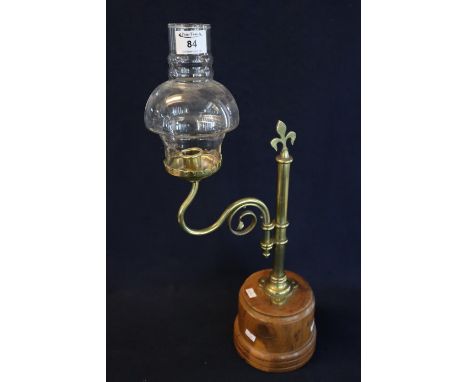 Brass reading candle lamp on turned yew wood base with scrolled sconce arm and clear shade. (B.P. 21% + VAT) No obvious damag