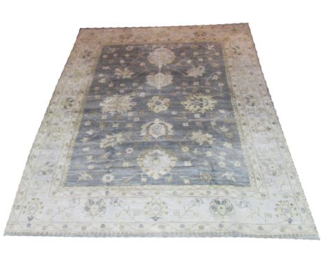 OUSHAK CARPET, linear medallions, scrolling vines and palmettes on a sky field with corresponding ivory border, 310cm x 242cm