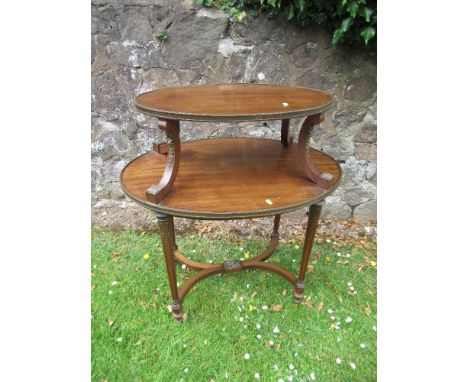 A two tired oval mahogany etegere raised on reeded legs united by cross stretchers diameter 30ins&nbsp;