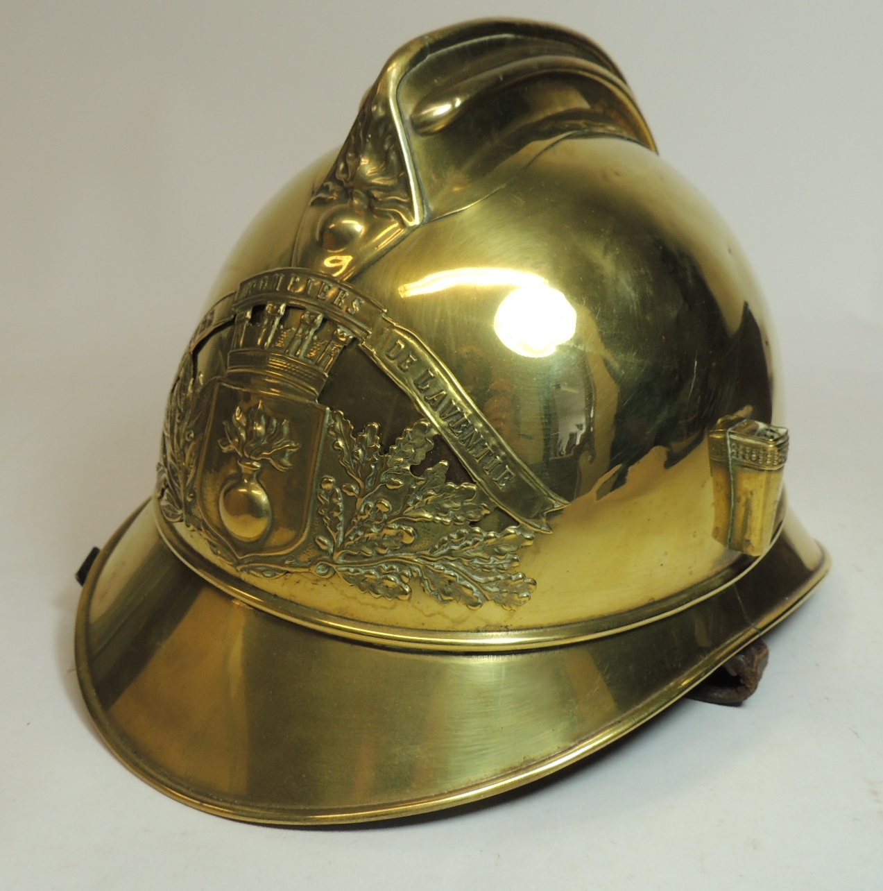 A French fire helmet, the brass helmet with applied badge, plume holder