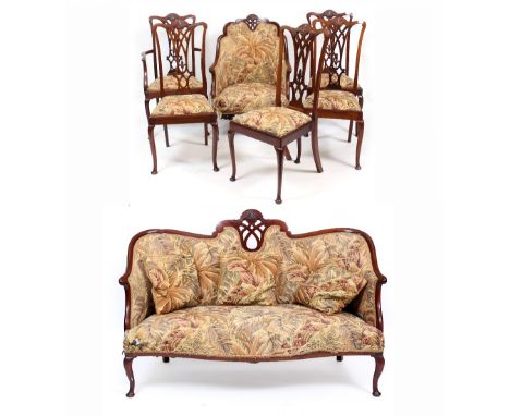 AN EDWARDIAN MAHOGANY SALON SUITE consisting of a small sofa with serpentine front together with an armchair and five matchin