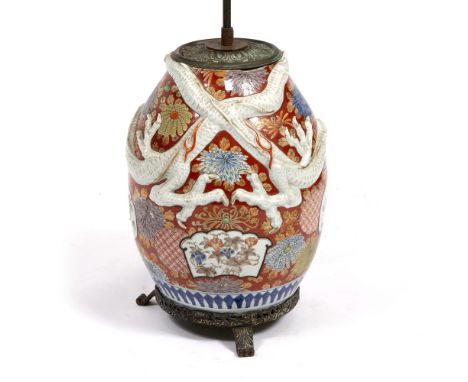 A TABLE LAMP constructed from a Chinese porcelain red ground ovoid vase, with entwined moulded dragon decoration, the vase an