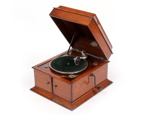 A PAIN'S OAK CASED GRAMOPHONE RECORD PLAYER with winding handle to the side and hinged doors to the front, 45.5cm wide x 53.5