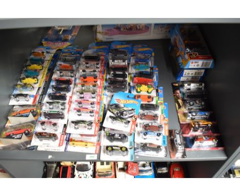 A shelf of Mattel Hot Wheels diecasts, all on display hanging bubble cards or boxed sets, 100+ including Legend of Speed, Fla