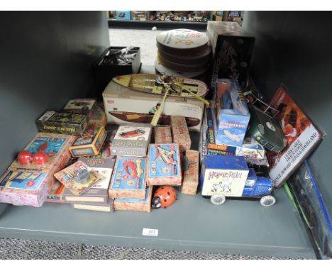 A shelf of modern reproduction Toys and Games including Home Run Chewing Gum Van, Hornby Porsche 911, tin plate Rowing Boat e