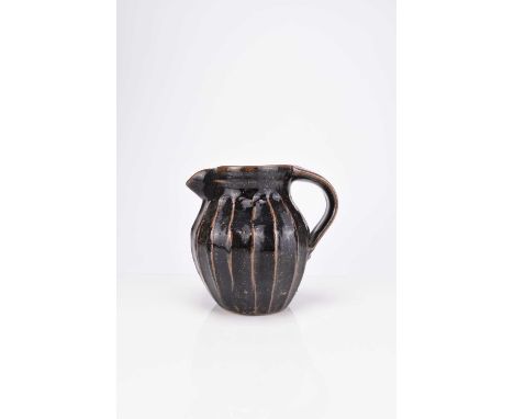 Trevor Corser (1938-2015)A Leach Pottery St. Ives studio pottery jug, of cut-sided form with a deep brown tenmoku glaze, pott