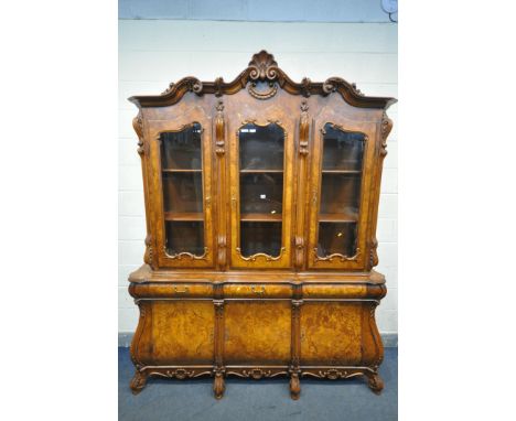 A REPRODUCTION BURR WALNUT DUTCH BOMBE DISPLAY CABINET, the top depicting foliate scrolls, three glazed doors, enclosing thre