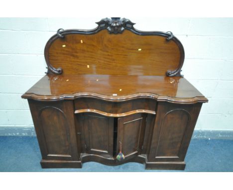 A VICTORIAN SERPENTINE SIDEBOARD, with a raised back, with two cupboard door, enclosing drawers and shelves, flanking a singl