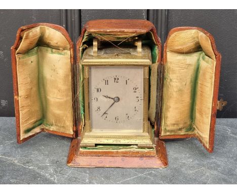 An unusual engraved brass carriage clock, with silvered dial, gong strike and push button repeat, height including handle 15c
