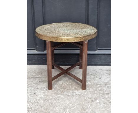 A brass top folding occasional table, inscribed with Islamic&nbsp;script, 59.5cm diameter.