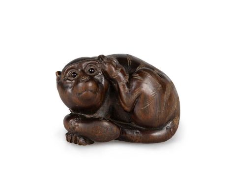 A JAPANESE FRUITWOOD NETSUKE carved as the mythical Japanese chimera Nue, the animal with the head of a monkey, torso of a ti