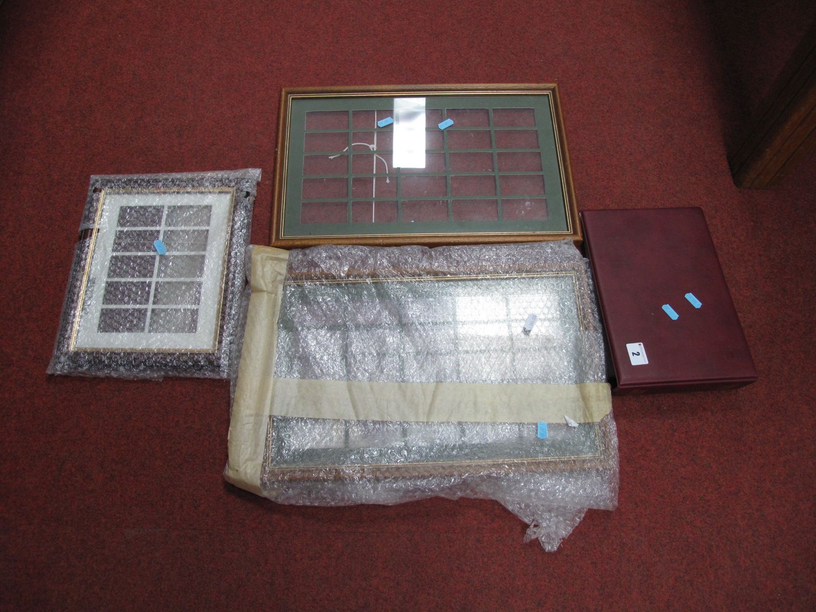 Three Frames With Card Mounts, for cigarette card display; together with an empty postcard album