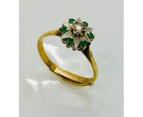 An 18ct gold diamond and emerald flower shaped ring with 9ct adjuster - Size R 