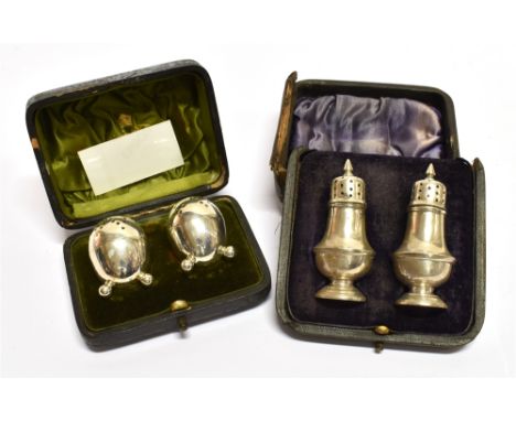 A LEATHER CASED PAIR OF VICTORIAN SILVR PEPPERETTES of schooner bottle form with part fluted and dot decoration, with flame f
