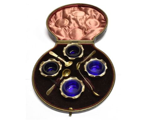 A CASED SET OF FOUR SILVER COULDRON SALTS AND SPOONS  with waved millegrain rim, complete with blue glass liners, hallmarks f