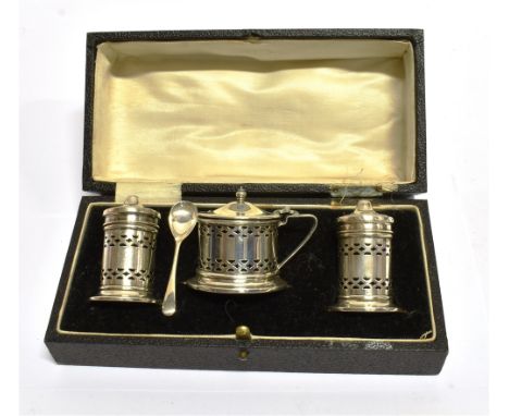 A BOXED THREE PIECE SILVER CONDIMENT SET of lighthouse form with pierced decoration, the mustard pot with spoon, blue glass l