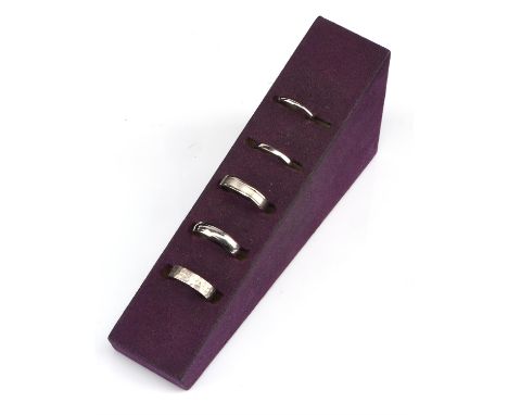 † A selection of five wedding bands, including a 2mm court shape wedding band, size L, a 2mm flat court band, size L, a 5mm D