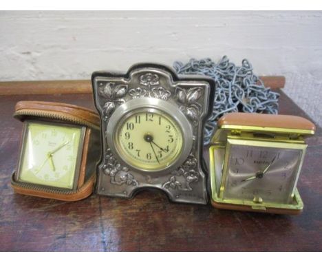 An early 20th century silver fronted dressing table clock, together with two travelling clocks 