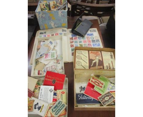 A stamp album, loose stamps, match box wrappers, cigarette and beer wrappers and a geometry set 