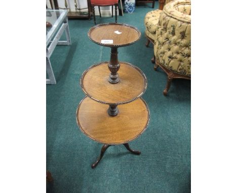 A MAHOGANY THREE TIER DUMB WAITER of circular form each moulded shelf joined by a baluster column on tripod support 90cm (h) 